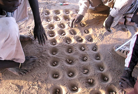 En África, los agujeros se hacen en un tablón de madera, o en hoyos de tierra