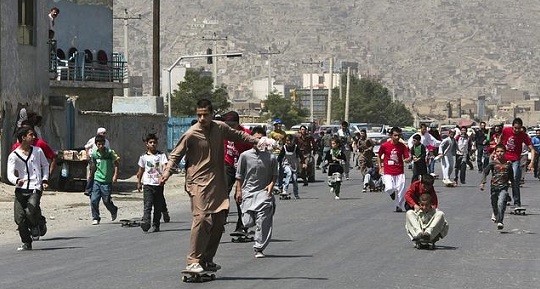 Jóvenes afganos en una carrera de monopatín por las calles de Kabul.